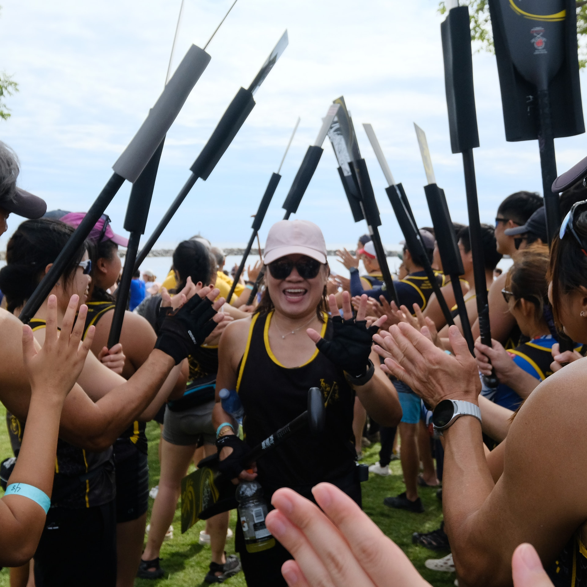 TOHK paddlers celebrating together with paddles raised
