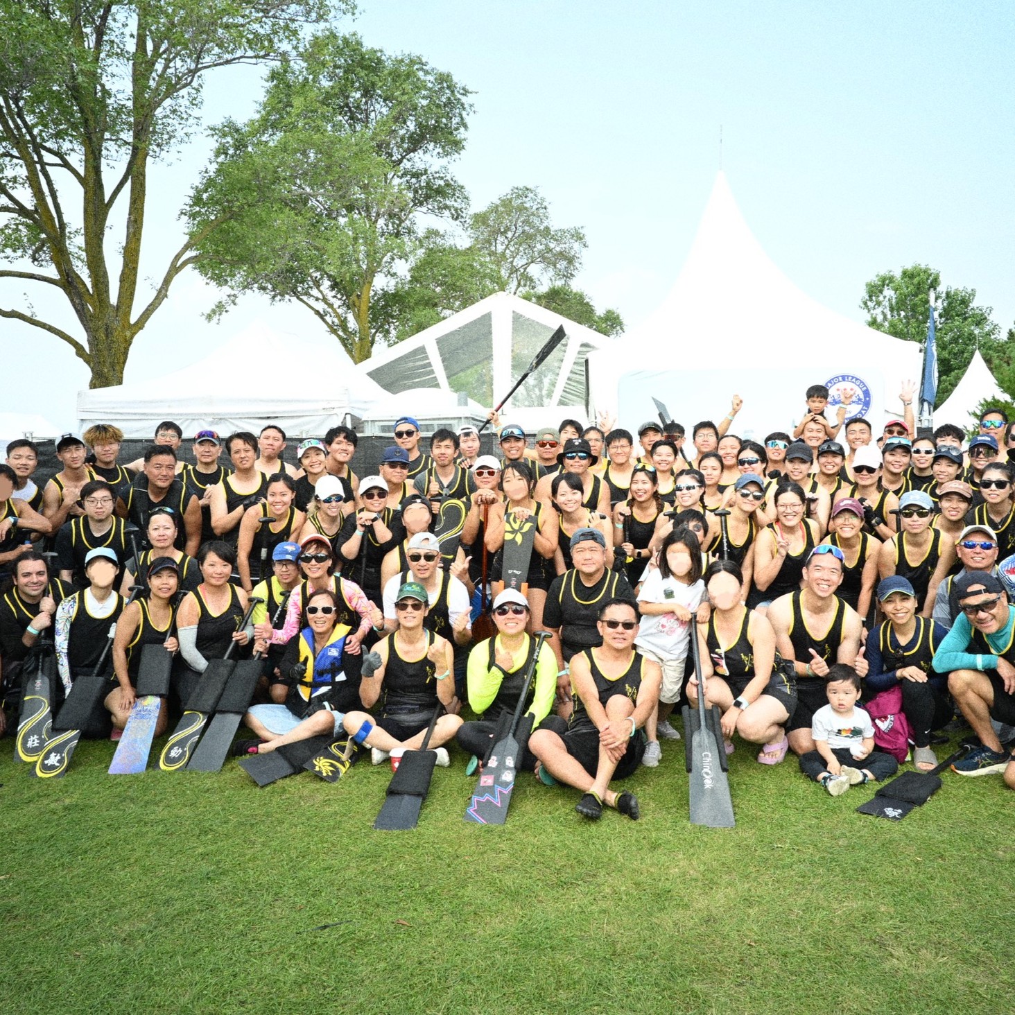 TOHK team group photo with paddles raised at the regatta site